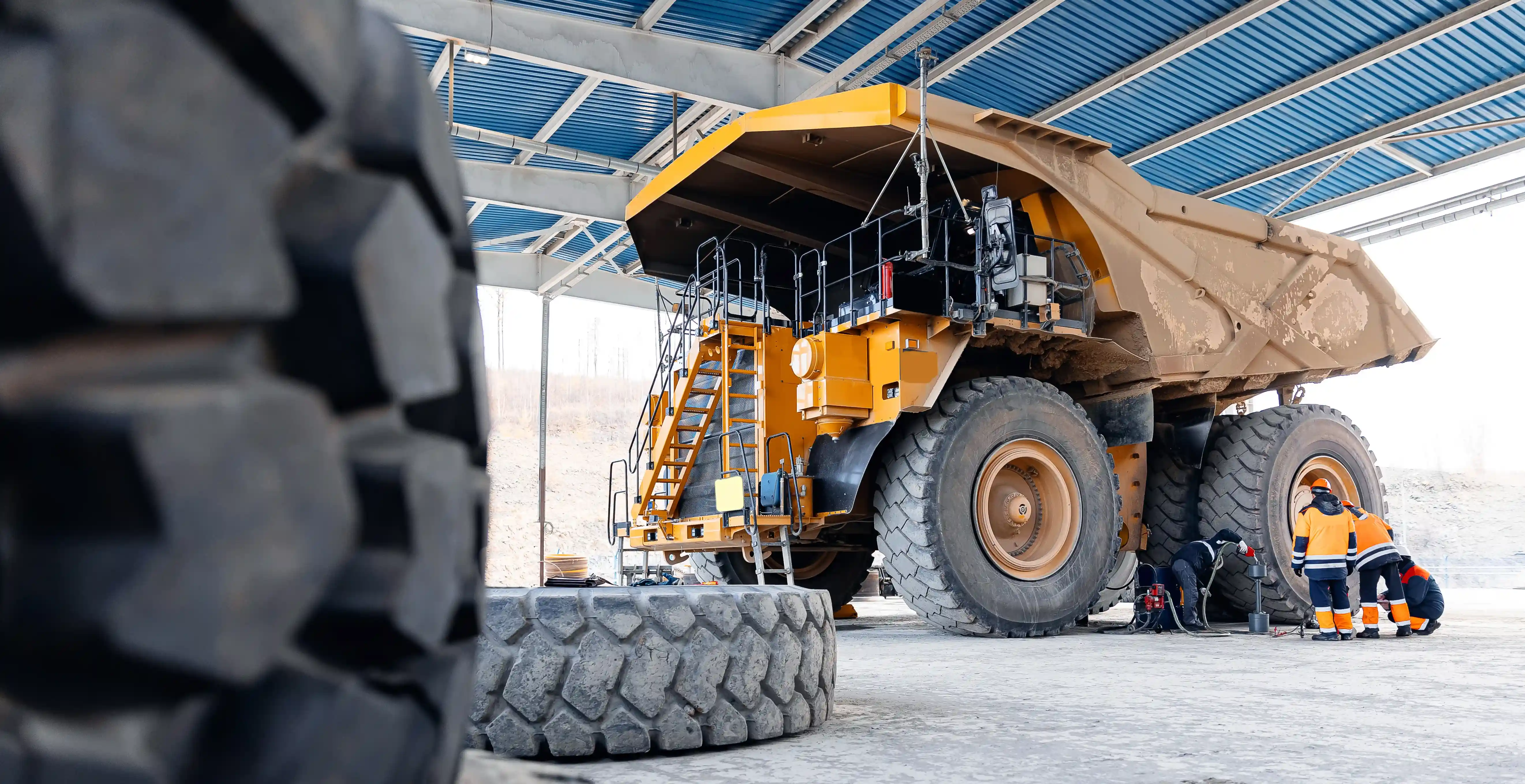 Some men inspecting a mining dump truck